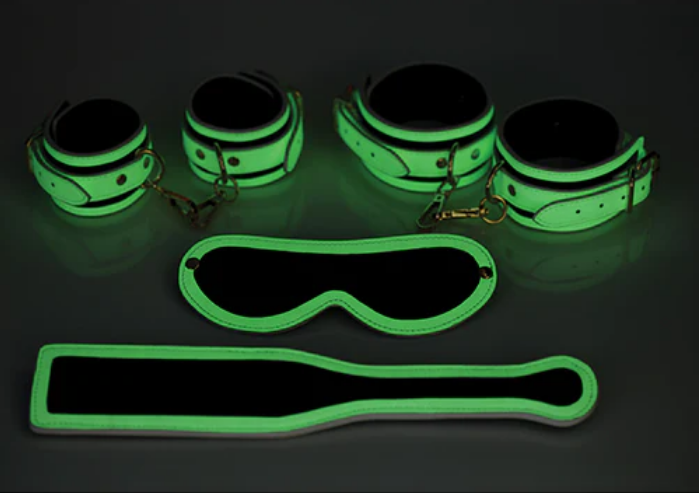 A Glowing Bondage Kit For Playing in the Dark! Add a kinky glow to your bedroom. This Glowing Bondage Kit makes it easy to tie up your sub and enjoy the world of bondage in the dark. The included cuffs, paddle, and blindfold are an attractive Quality Crafted White Eco Leather with Gold Hardware that in the light transform into glowing tools of kink so you can play in dimly lit scenes with ease.